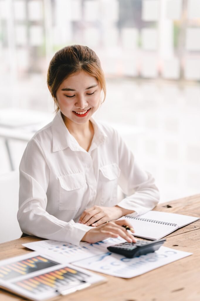 Portrait of an Asian woman working on a tablet computer in a modern office. Make an account analysis